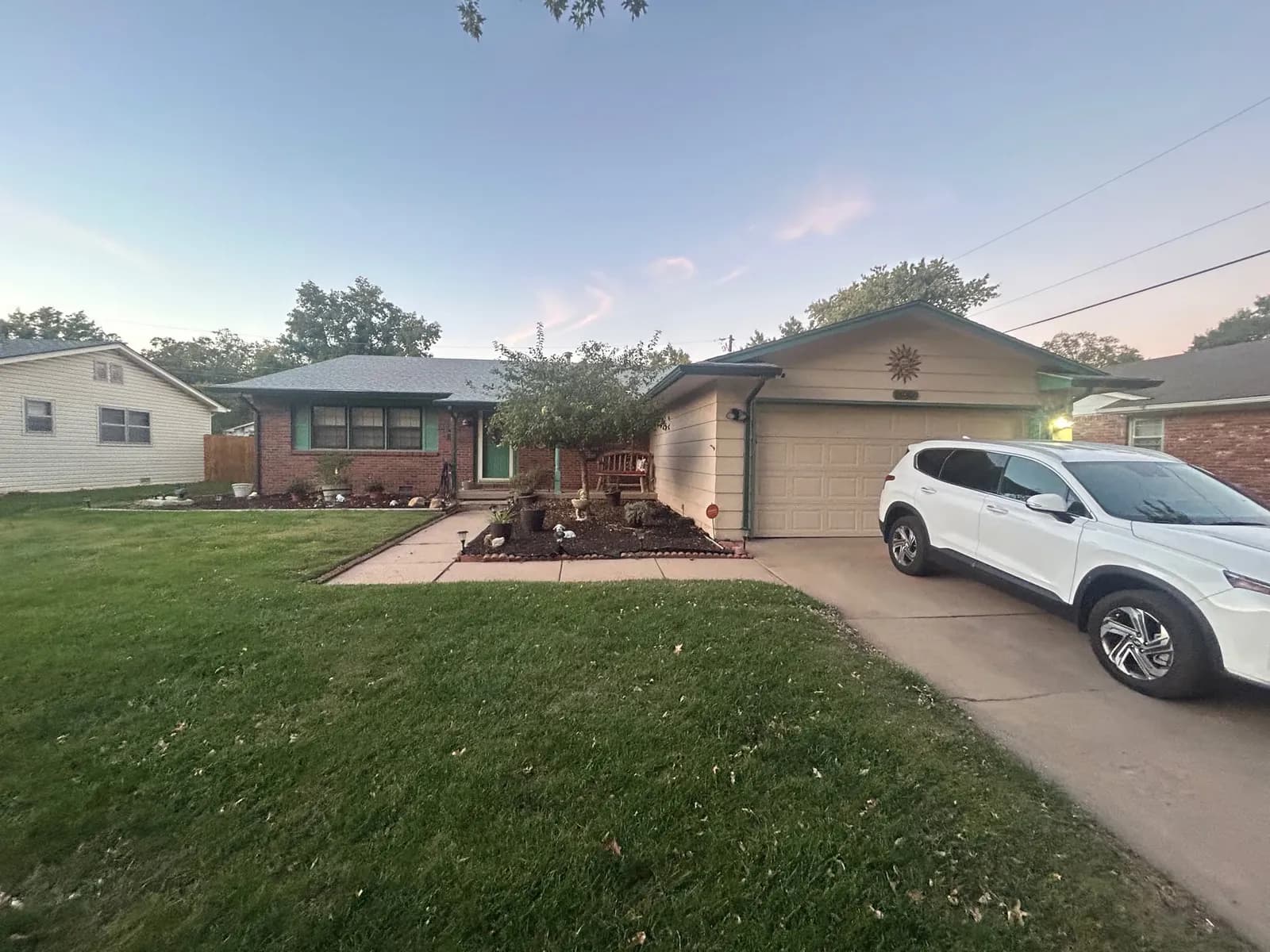 Brick ranch home in Wichita before repainting, with dated brown garage door and trim