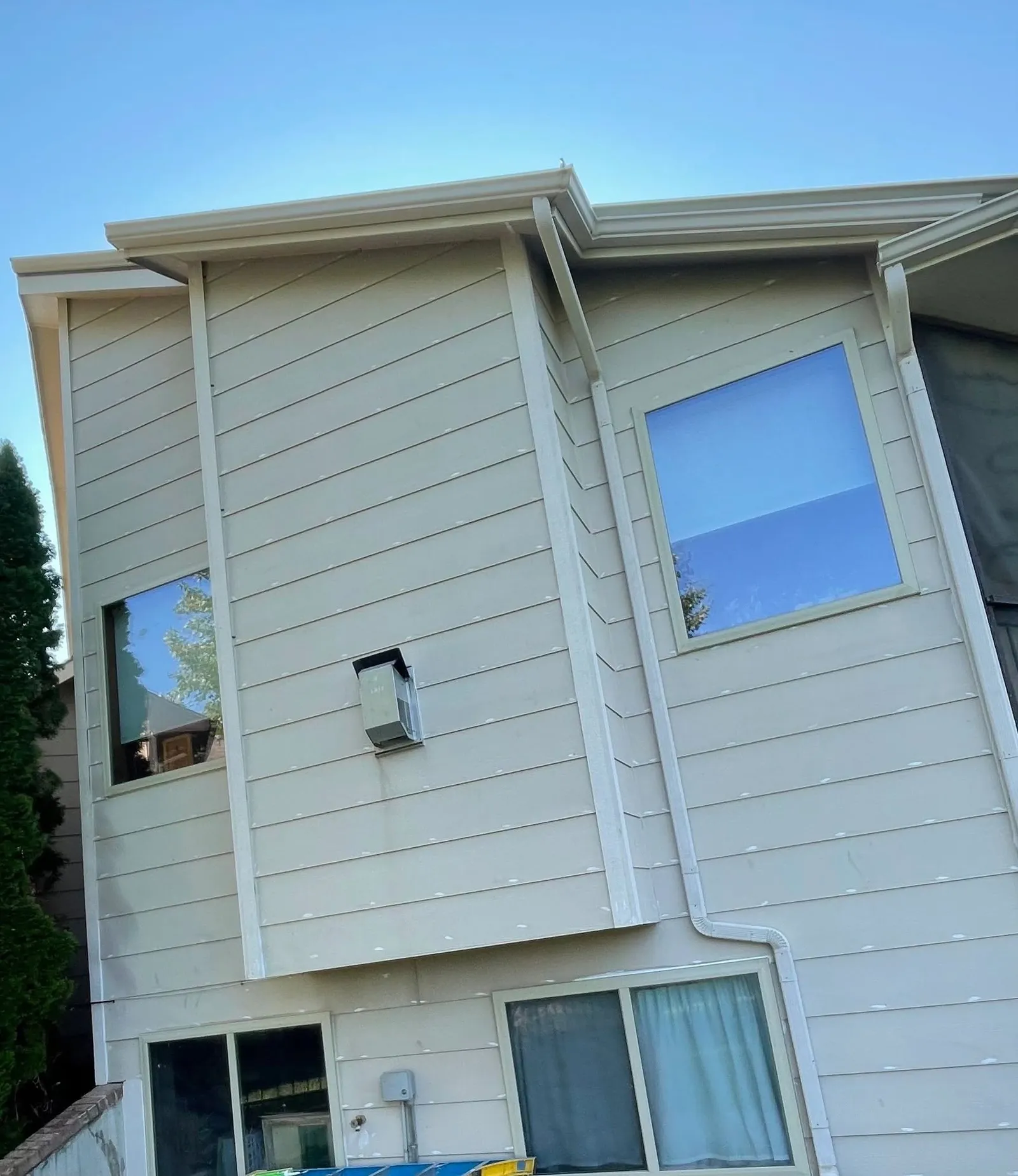 Split-level Wichita home before repainting, its cream siding faded and chalky